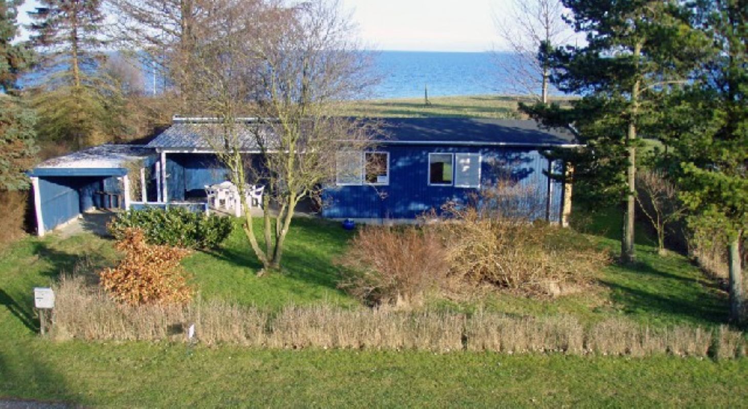 Huset fra vejen med havet i baggrunden.