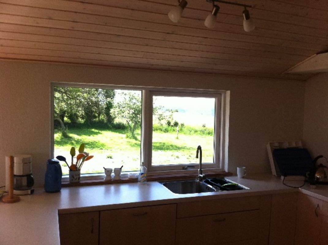 Kik fra køkkenvindue mod vest og aftensolen, der går ned over havet.View form the kitchen window.